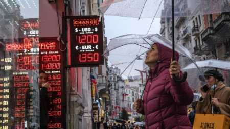 Хора гледат валутния курс на чейндж бюро в Истанбул, 23 ноември 2021 г. 