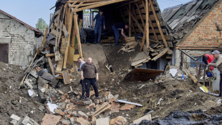 Хора чистят разрушения след ракетна атака в Золочив, в района на Харков, 14 май 2025 г.