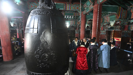 Кметът на Сеул О Се Хун, (на втори план вляво) и други участници удрят огромна камбана, за да посрещнат Новата година по време на събитие за обратно броене в павилиона Bosingak в Сеул, Корея, 1 януари 2024 г.