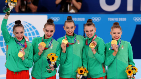 Мадлен Радуканова (средата) и Ансамбълът по художествена гимнастика, спечелил олимпийското злато в японската столица
