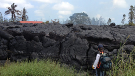 Снимка, предоставена от USGS, показва геолог от Хавайската вулканична обсерватория (HVO), който изследва застинал поток лава, Хавай, САЩ, архив, ноември 2014 г.