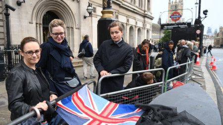 Хора очакват зад парапет процесията с ковчега на Елизабет Втора в Лондон, 14 септември 2022 г.