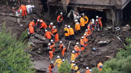 Японски работници разчистват път от свлечена кал след поройните дъждове