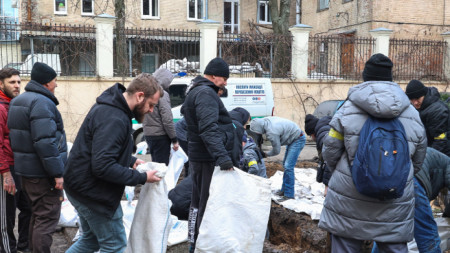 Украинци в Харков пълнят чували с пясък, за да направят ограждения срещу атаки.