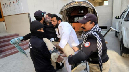 Пакистански служители по сигурността пренасят ранен след взрив в джамия в град Пешавар