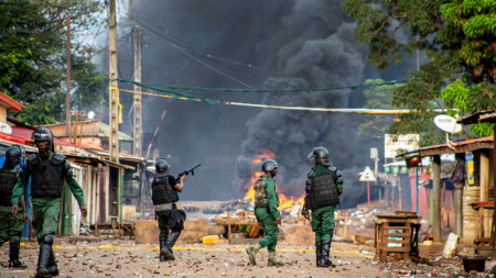 Полицията в Гвинея разпръсква демонстранти зад барикади, протестиращи срещу преизбирането на президента Алфа Конде за трети мандат, 19 октомври 2020 г.