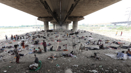 Индийци почиват се крият от горещината под мост в Делхи, 10 май 2022 г.