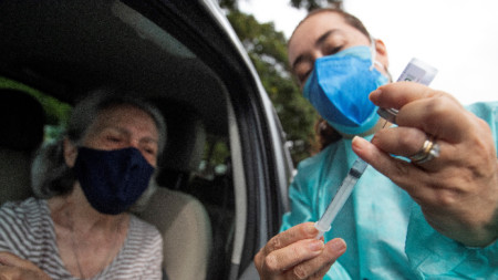 Здравен работник приготвя доза за ваксинация в автомобил в столицата Бразилия, февруари 2021 г.