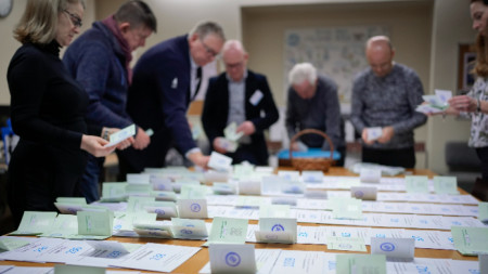 Членове на избирателна комисия броят подадените бюлетини в избирателно бюро в Талин през март 2023 г. 