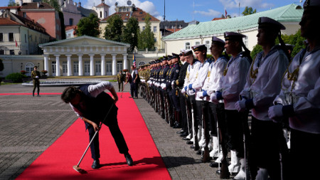 Жена почиства червения килим преди пристигането на президента на САЩ Джо Байдън за официалната церемония по пристигането му с президента на Литва