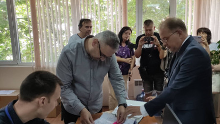 Калоян Сухоруков (в средата) преглежда документи за регистрация