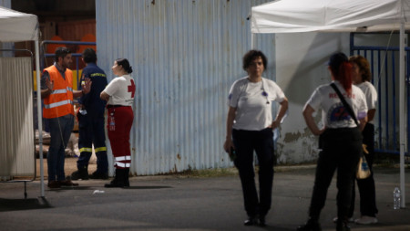Доброволци стоят пред склад, в който се лекуват бежанци и мигранти след смъртоносното корабокрушение край Пилос на пристанище Каламата, югозападно от Атина, Гърция, 15 юни 2023 г.