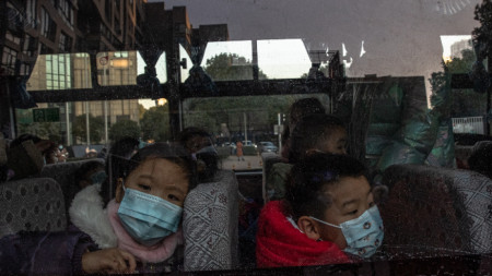 Деца чакат в автобус в Ухан родителите им да ги вземат, след като са били на детска градина, Китай, 31 декември 2020 г. 