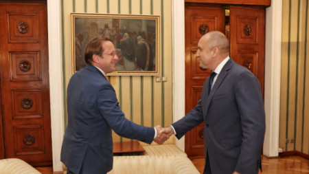 Еврокомисарят Оливер Вархеи (вляво) и президентът на България Румен Радев