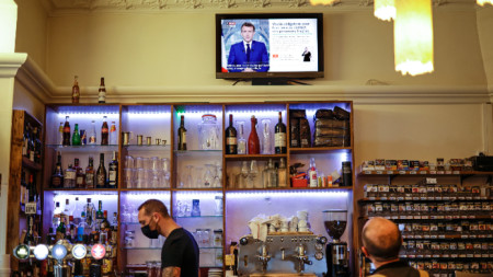 Клиент на бар гледа френския президент Еманюел Макрон, който прави телевизионно обръщение към нацията за Covid-19, Париж, 12 юли 2021 г.
