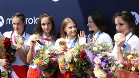 Олимпийските шампионки показват златните си медали.