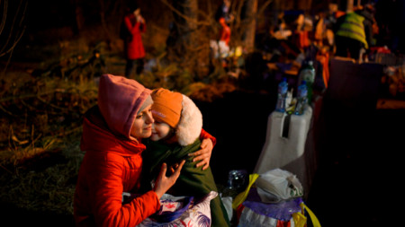 Жена прегръща детето си, след като е влязла в Румъния от Украйна