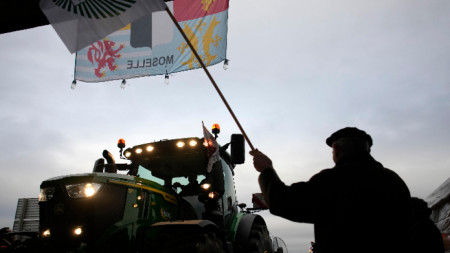 Местен жител маха на трактор на барикада, докато фермери блокират магистрала край Жосини, източно от Париж, 30 януари 2024 г. 