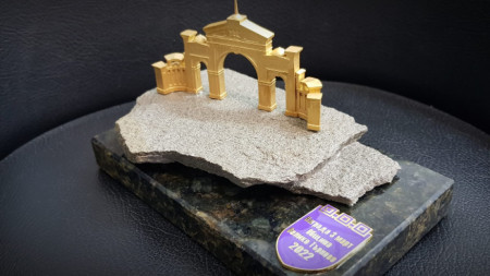 Академичната награда е позлатена настолна реплика на Арката на генералите, поставена върху камък от подножието на крепостта Царевец