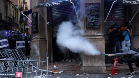 Протестиращ използва пожарогасител срещу полицейските части в деня на Каталуния, Диада, Барселона, 11 септември 2021 г.