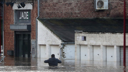 Мъж гази в наводнена улица, докато река Аа прелива в Аркес, Франция, 3 януари 2024 г.