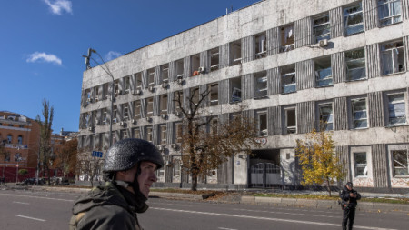 Украински военни на пост край повредена сграда, която е близо до обект, поразен от ракетен удар в центъра на Киев, 10 октомври 2022 г.