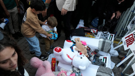 Истанбул, 21 октомври 2023 г. - Деца оставят играчки над макети на ковчези, докато протестиращи организират символично погребение на убити палестински деца в Газа по време на митинг пред израелското консулство. 