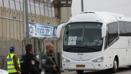 Автобусът на Международния комитет на Червения кръст (МКЧК) пристига във военния затвор Офер на Западния бряг, северно от Ерусалим, 25 ноември 2023 г., преди очакваното освобождаване на палестински затворници. Израел и Хамас се споразумяха за четиридневно прекратяване на огъня, като 50 израелски заложници, жени и деца, трябва да бъдат освободени от Хамас