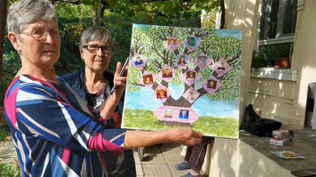 Снимката е архив на Община Стара Загора.  
Дъщерите на 101-годишния 
дядо Петко Колев от с. Михайлово позират с родословно дърво на своите предци и наследници.