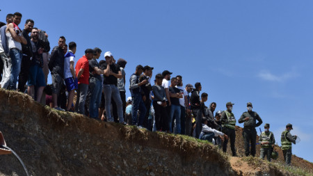 Мигранти чакат да се промъкнат през ограда в опит да преминат границата от Мароко до испанския анклав Сеута, Северна Африка, 18 май 2021 г. 