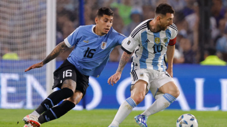 Меси се опитва да се измъкне от защитника на Уругвай Оливейра.