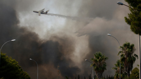 Самолет участва в гасенето на горския пожар в района на Варипомби, североизточно предградие на Атина, 3 август 2021 г.