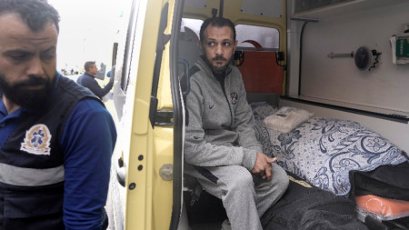 Палестинецът Сами Ал Бахнасауи седи до тялото на съпругата си, която почина в египетска болница след наранявания от войната в Газа, докато пресичат пункта Рафах на връщане към ивицата Газа, Египет, 27 ноември 2023 г.