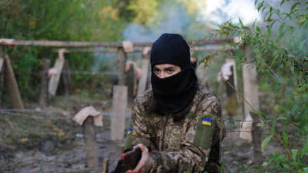 Жена държи дървена реплика на пушка, докато участва във военно обучение, организирано от украинската политическа организация 