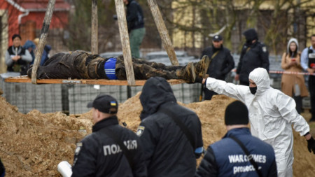 Полицаи вадят тяло от масов гроб в Буча край Киев - столицата на Украйна, 8 април 2022 г.