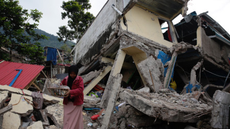 Жителка на град Чианджур събира вещи от разрушената си къща, 22 ноември 2022 г.
