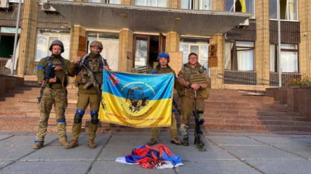 Украински военни държат знамето на Украйна пред сградата на градския съвет в Купянск