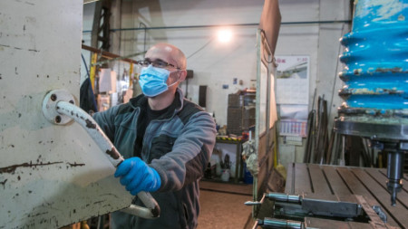 Мъж със защитна маска работи в цех в Сарогоса, Испания, след като от днес бяха възобновени някои икономически дейности.