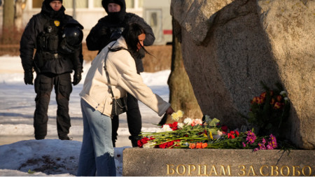 Жена полага цветя в памет на Алексей Навални пред мемориал в Санкт Петербург, 18 февруари 2024 г.