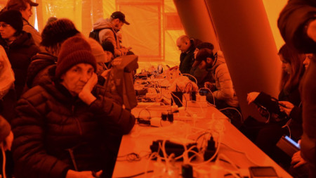 Украинци зареждат мобилните си телефони в палатка в Херсон, който силите на Киев неотдавна си върнаха. В града, който е без ток, са оборудвани палатки с отопление, храна и достъп до интернет, 22 ноември 2022 г.