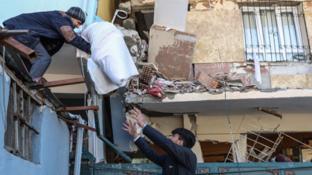 Хора прибират вещи от сграда в Хатай, пострадала от земетресенията по-рано този месец, 22 февруари 2023 г.