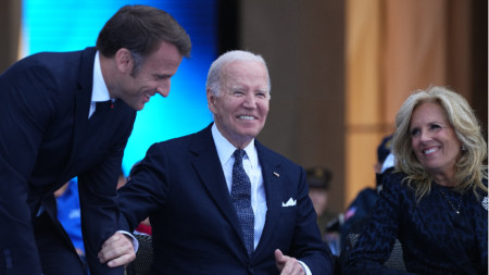 Президентът на САЩ Джо Байдън, френският президент Еманюел Макрон (вляво) и първата дама Джил Байдън по време на възпоменателната церемония за отбелязване на 80-ата годишнина от десанта в Нормандия, 6 юни 2024 г., в Колвил-сюр-Мер, Франция.