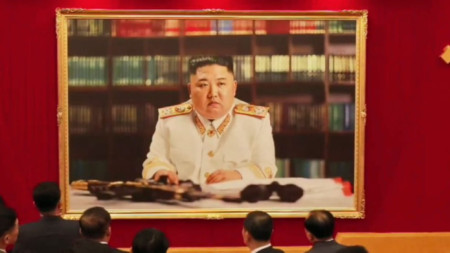 Делегати на конгреса на комунистическата партия в Пхенян проучват новия портрет на лидера Ким Чен-ун.