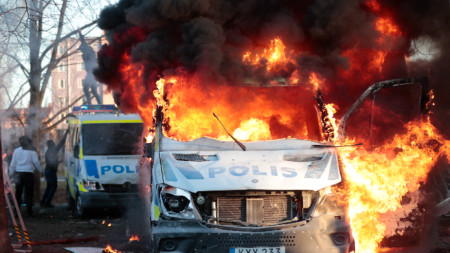 Полицейски коли горят, след като контрапротестиращи ги подпалиха на мястото, където Расмус Палудан, партиен лидер на Stram kurs, имаше разрешение за събиране, Йоребру, Швеция, 15 април 2022 г