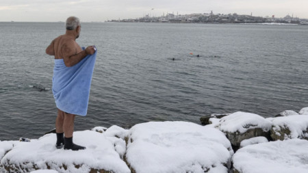Мъж се завива в кърпа, след като поплува в Босфора в Истанбул, 25 януари 2022 г.