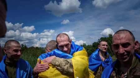 Украински военнослужещ прегръща свои другари, след като е освободен при размяна на военнопленници