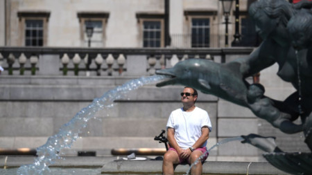 Мъж се разхлажда във фонтана на Трафалгар скуеър в Лондон, 18 юли 2022 г.