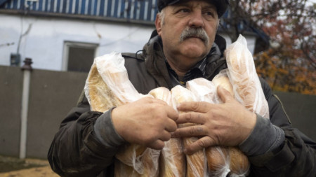 Мъж носи хляб, доставен от доброволци в село източно от Херсон, 20 ноември 2022 г.