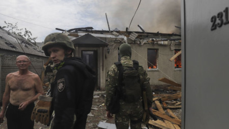 Украински военни говорят с местен мъж до подредена от руски обстрел къща в Лисичанск, Източна Украйна, 2 юни 2022 г.