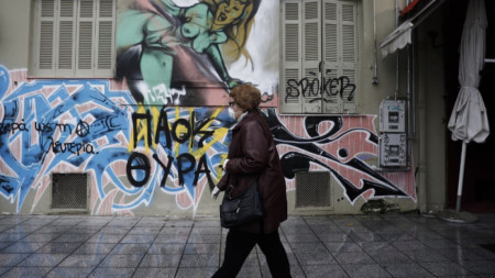 Възрастна жена с маска се разхожда в центъра на Солун.